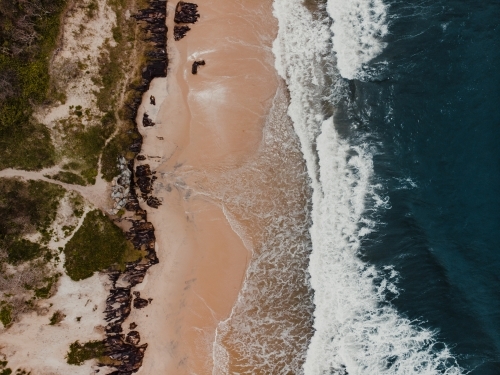 Drone shot of waves crashing on a beach from above - Australian Stock Image