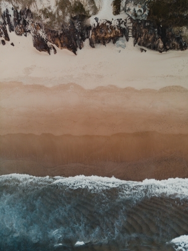 Drone shot of waves crashing on a beach from above - Australian Stock Image