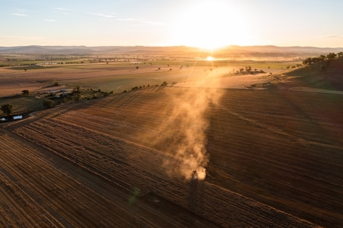 Drone view of combine harvester at sunset - Australian Stock Image