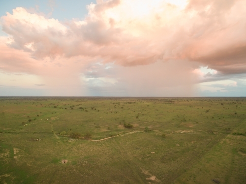 Drone view of rain over green paddock