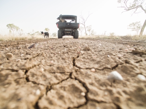 Drought Cracked Ground with Buggy in background - Australian Stock Image