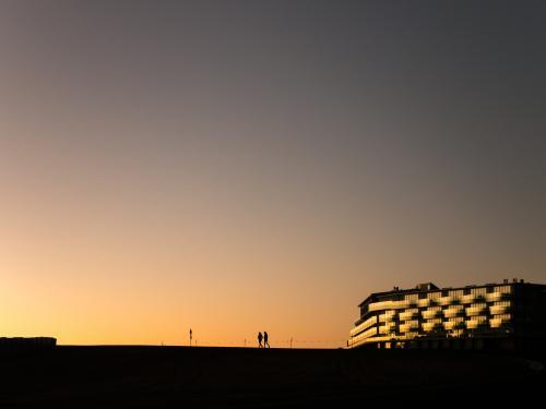 Dusk silhouette of 2 walkers and a hotel on Mt Panorama Racing Circuit - Australian Stock Image