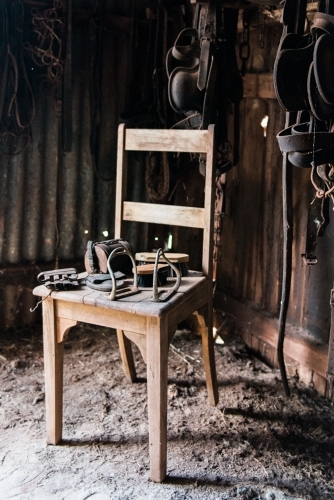 Dusty old items on a chair in a tack shed - Australian Stock Image