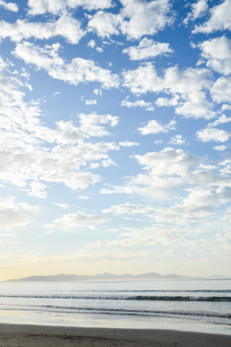 Early morning at the beach with Wilsons Prom in the distance - Australian Stock Image