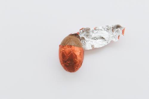 Easter egg with half unwrapped red foil - Australian Stock Image