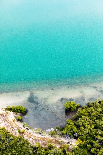 edge of island with mangroves and bright blue water - Australian Stock Image