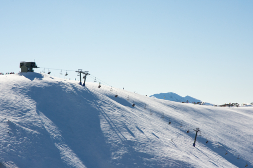 Edge of mountain with ski lift and blue sky - Australian Stock Image