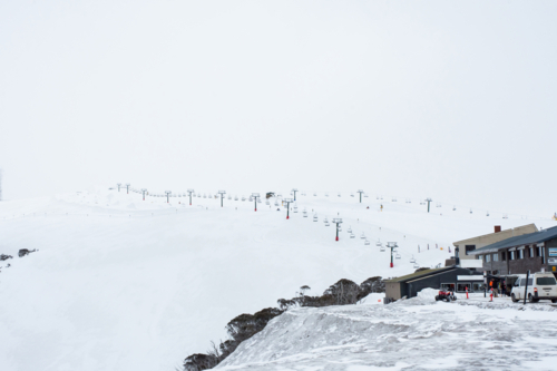 Edge of ski village with ski lift in distance - Australian Stock Image
