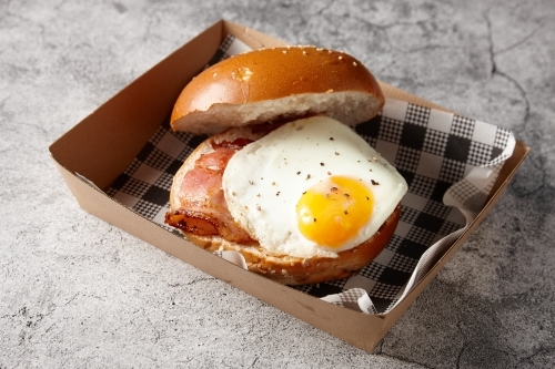 Egg and bacon roll in cardboard tray - Australian Stock Image