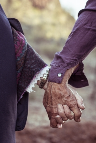 Elderly couple holding hands