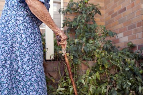 Elderly lady inspecting the garden at an aged care facility - Australian Stock Image