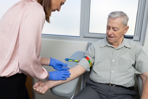 elderly male patient sitting in phlebotomy chair for blood test
