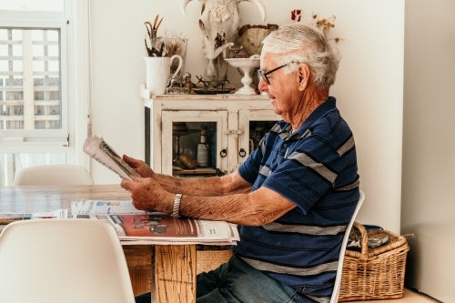 Elderly man reading the daily newspaper.