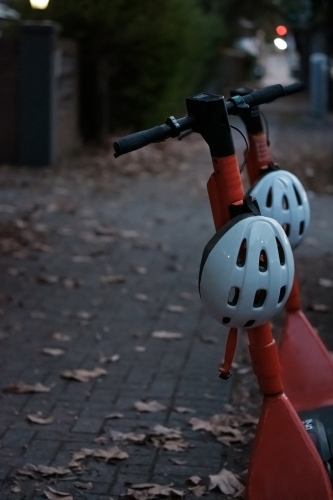 Electric Scooters in a city street with Autumn Leaves - Australian Stock Image