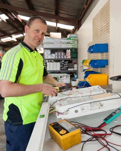 Electrician testing power board in his workshed
