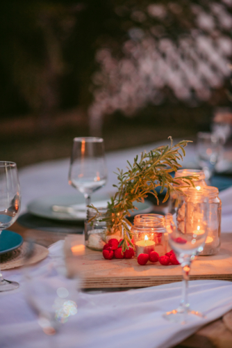Elegant outdoor dinner setting with candles and fresh decorations in a warm evening atmosphere - Australian Stock Image