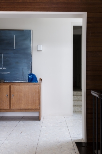Entry foyer buffet and artwork viewed from living area in mid century modern home