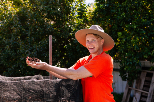 environmentalist composting advocate woman holding dirt made in garden compost system - Australian Stock Image