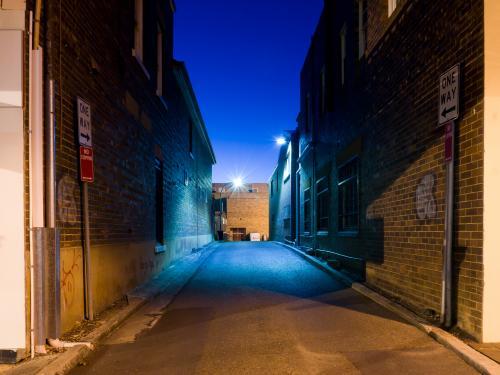 Evening shot of an one way alleyway with blue light and sky