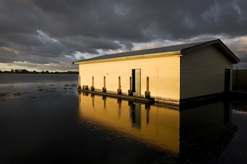 Evening sun shining on old boat shed - Australian Stock Image