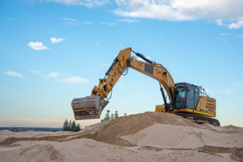 Excavator at work digging sand at Dolls Point - Australian Stock Image