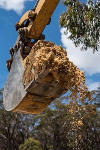 Excavator bucket full of yellow sand - Australian Stock Image