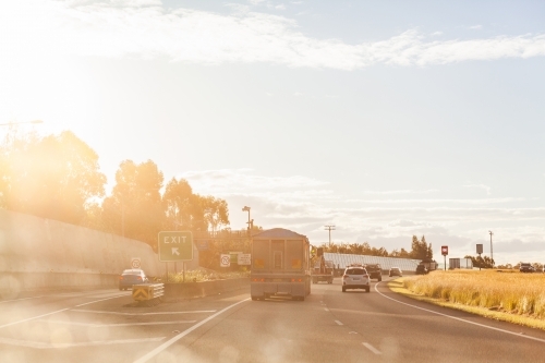 Exit ramp on road bypassing inner Sydney in golden light flare haze - Australian Stock Image
