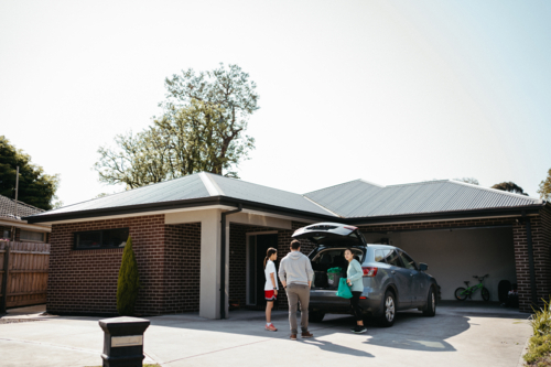 Family loading things into the boot of the car - Australian Stock Image