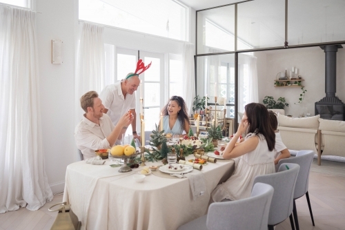 Family of five sitting around Christmas table - Australian Stock Image