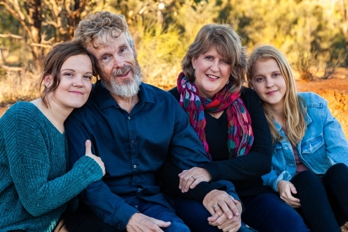 Family of four with teen and adult daughters siting together - Australian Stock Image