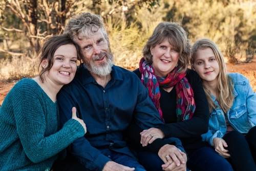 Family of four with teen and adult daughters siting together - Australian Stock Image