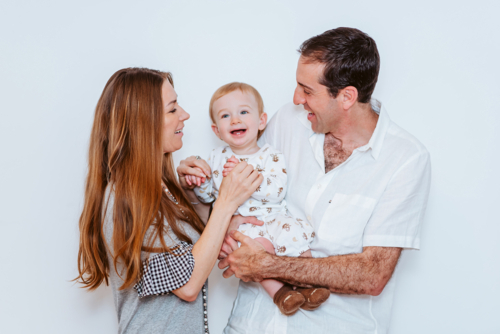 family of three playing together in white background (young boy, mother and father) - Australian Stock Image