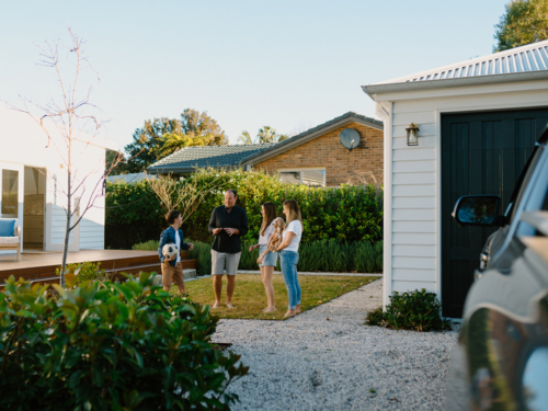 Family outside their house in the garden. - Australian Stock Image