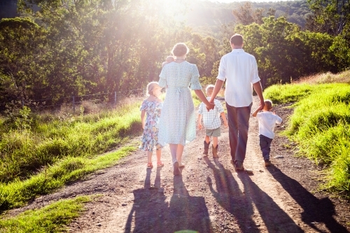Family walking down farm driveway together - Australian Stock Image