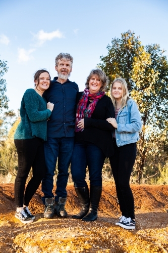 Family with teenage daughters together in australian landscape - Australian Stock Image