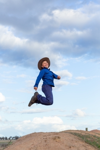 Farm boy jumping in the air - Australian Stock Image