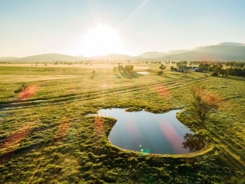 Farm dam at sunset on green farmland - Australian Stock Image