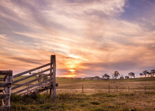 Farm fence and cattle ramp at sunset - Australian Stock Image