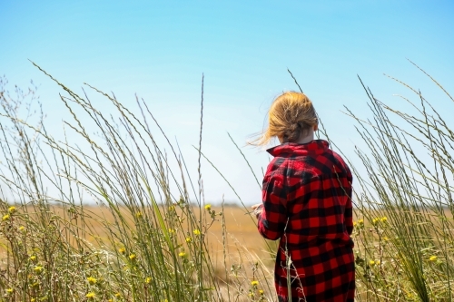 Farm girl in long grass on rural property - Australian Stock Image