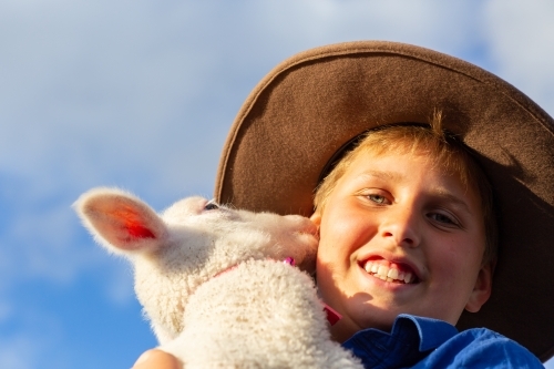 Farm kid with his pet lamb - Australian Stock Image