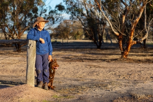 farm kid with his red kelpie dog by his side - Australian Stock Image