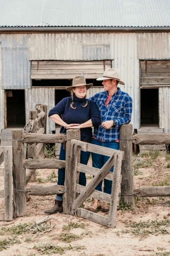 Farming couple smiling in the sheep yards - Australian Stock Image