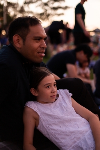 father and daughter relaxing together at carols by candlelight