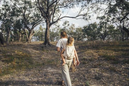 Father and daughter walking through bushland