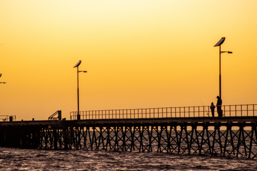 Father and son fishing on jetty - Australian Stock Image