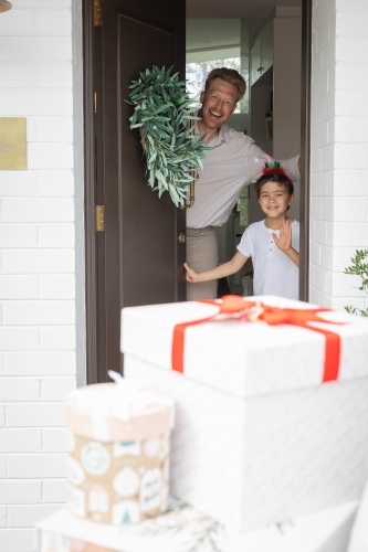 Father and son opening door with presents outside - Australian Stock Image