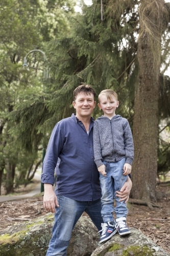 Father and son standing on rocks outdoors - Australian Stock Image