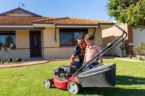 father and toddler with lawnmower