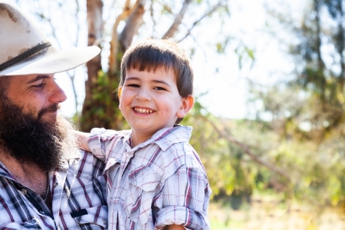 Father and young son hugging outside - Australian Stock Image