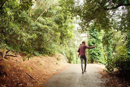 Father carrying a child walking and pointing - Australian Stock Image
